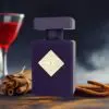 A bottle of perfume sitting next to some cinnamon sticks.
